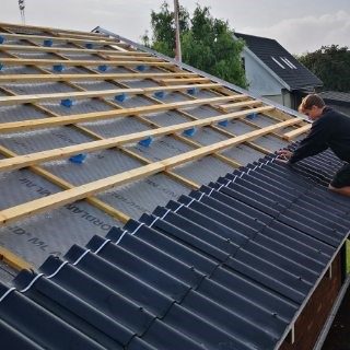 Håndværker på tag med stige